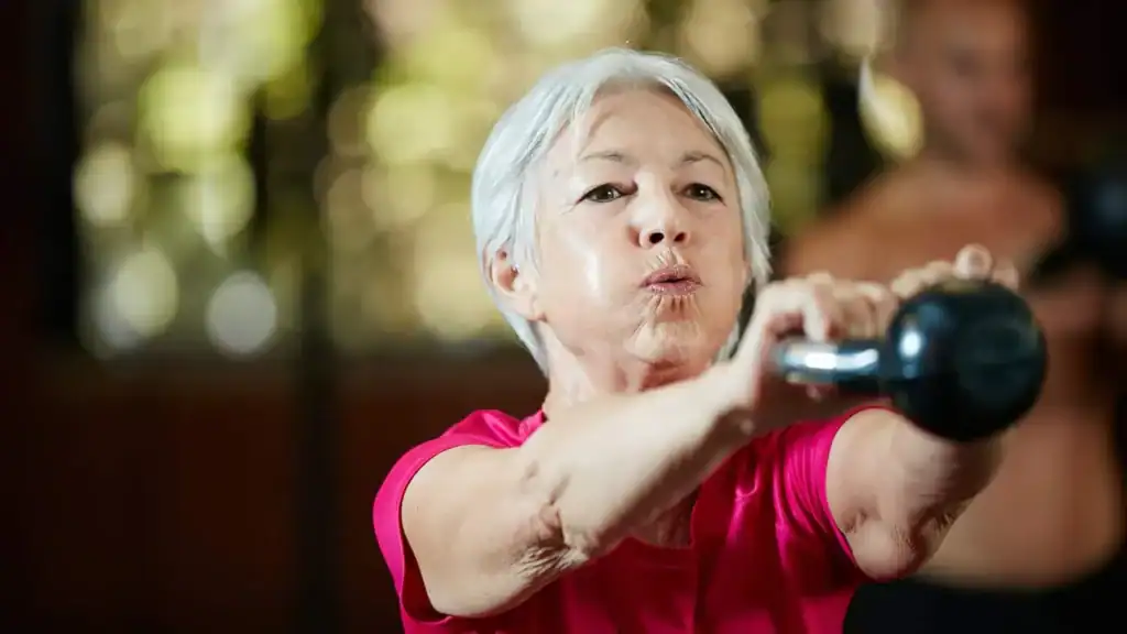 Toning Arms After 60: Empowering Womens Fitness Through Effective Weight Training 1 Older woman doing weight training West Tilbury to help her strength and longevity