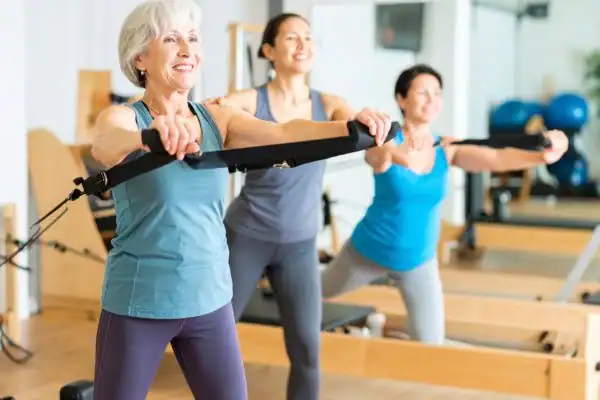 Toning Arms After 60: Empowering Womens Fitness Through Effective Weight Training 2 older woman doing weight training West Tilbury and resistance in the gym to tone upper arms