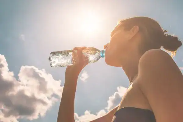 Hydration: The Secret Ingredient for a Toned Stomach and Enhanced Fitness 3 Image of woman drinking water to hydrate West Tilbury after run.