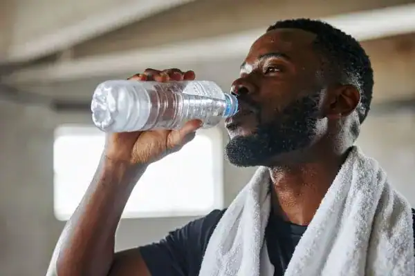 Hydration: The Secret Ingredient for a Toned Stomach and Enhanced Fitness 1 Image of man drinking water to improve hydration West Tilbury after work out.
